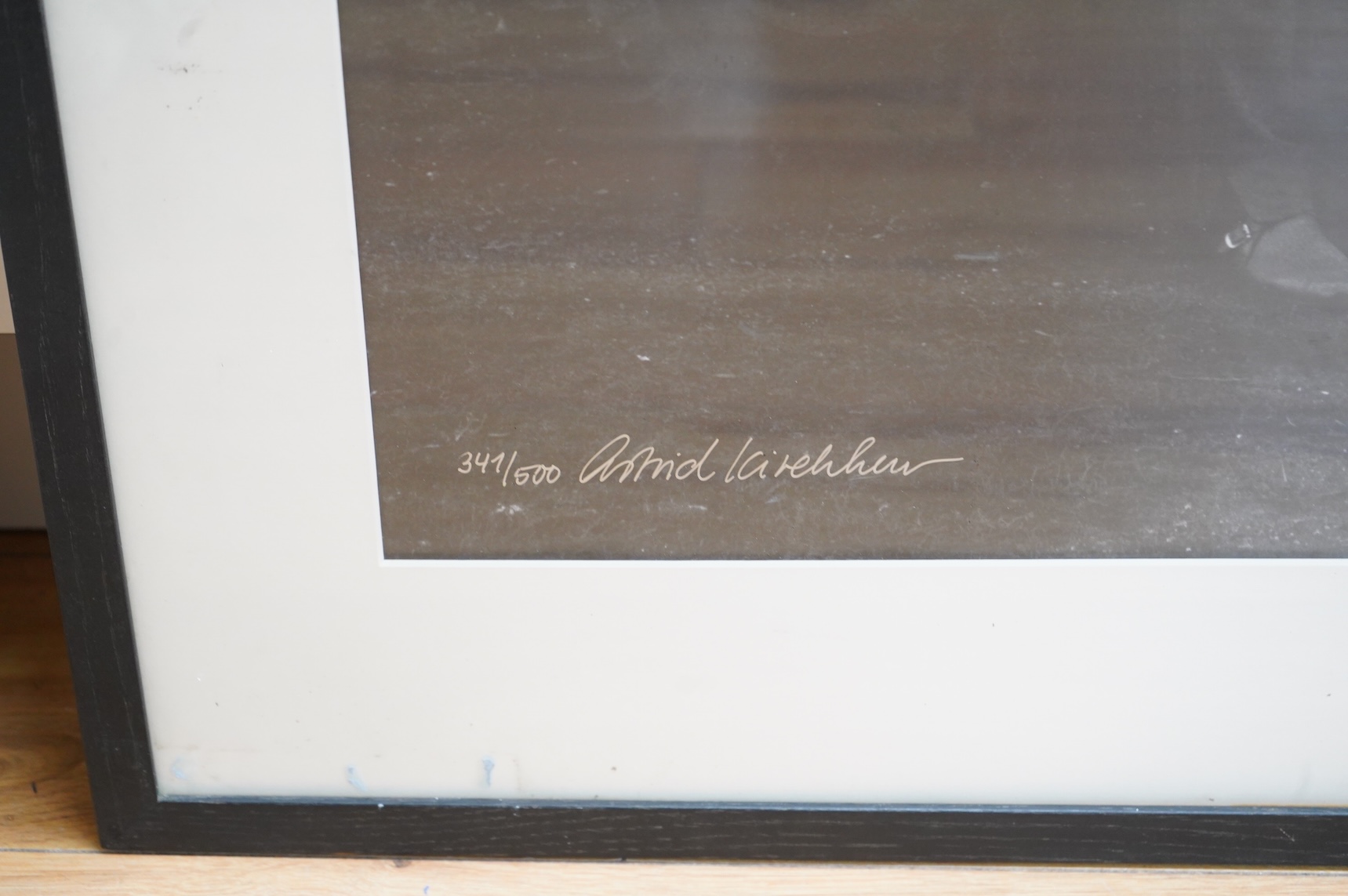 A framed and mounted black and white photograph of The Beatles by Astrid Kirchherr, showing John Lennon, George Harrison and Stuart Sutcliffe posing with guitars in front of a Land Rover, limited edition 341/500 and sign